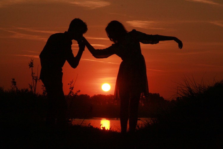 love couple kissing on hand at sunset