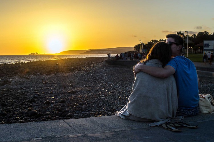 sweet couple kissing at sunset