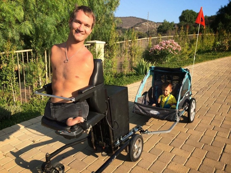 Nick Vujicic Limbless motivational speaker takes his son out for a roll